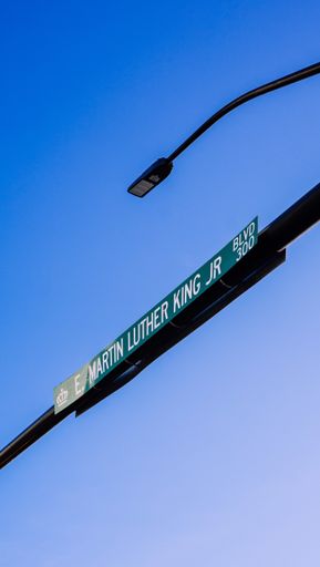 A vertical low angle shot of a road sign under a blue clear sky