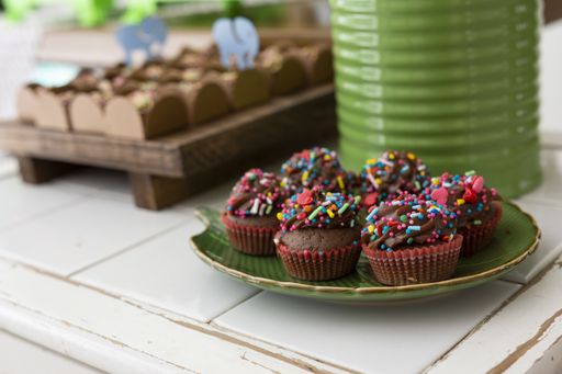 A closeup shot of chocolate cupcakes with colorful candies on the birthday party table