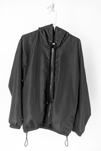 A black coat hanging isolated on a white background