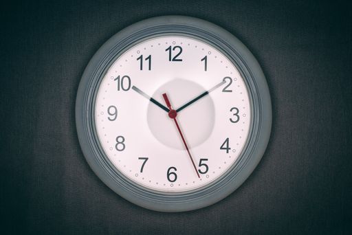 A closeup shot of a watch on a gray wall