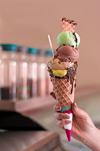 A selective focus shot of a female hand holding a tasty appetizing ice cream