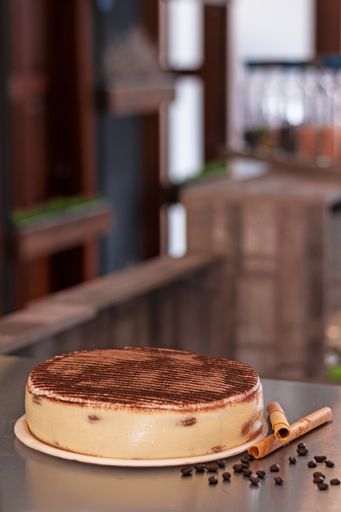A selective focus shot of an appetizing cake with cinnamon sticks and coffee beans
