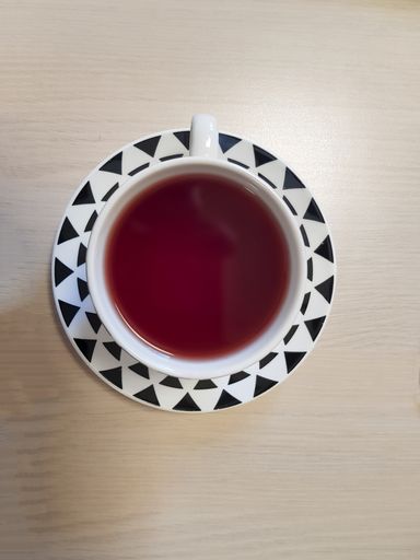 An overhead shot of a cup of tea on a wooden table