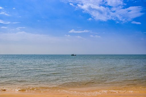 A beautiful view of a calm ocean with an old floating ship in Vietnam at daytime