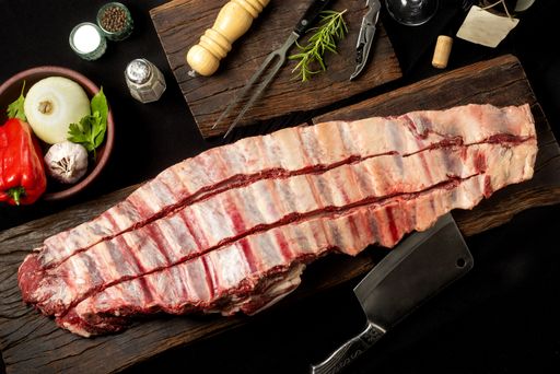 The fresh raw pork ribs on a cutting wooden board with spices