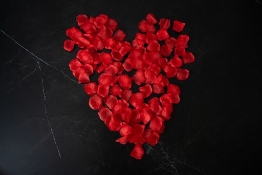 An overhead shot of a heart figure made of rose petals - Valentine's day concept