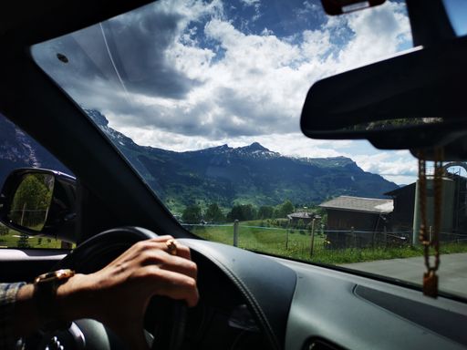 A beautiful shot of natural mountains full of greenery taken from inside a car