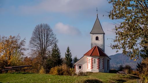 This beautiful church stands alone on a grassy hill, surrounded by trees
