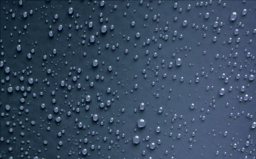 A top view of beautiful dark blue surface with water droplets