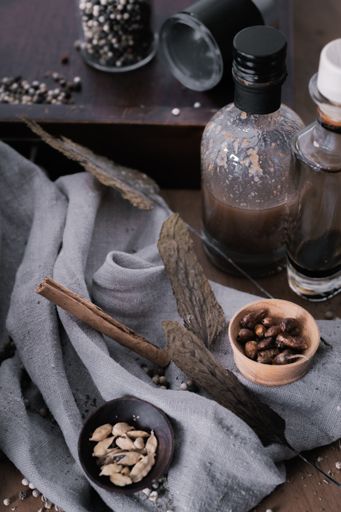 A vertical shot of a rustic backdrop with various spices and bottles