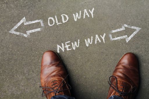 An overhead shot of a person standing in the middle of two choices with arrows
