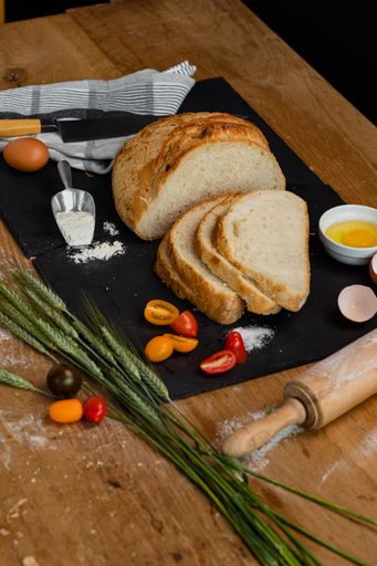 A vertical shot of a freshly baked loaf of white bread on a rustic background