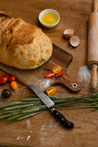 A vertical shot of a freshly baked loaf of white bread on a rustic background