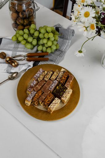 A plate of assorted homemade cakes with grapes and nuts on the table