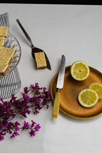 A plate of sliced lemons on the table with fresh demon-cakes