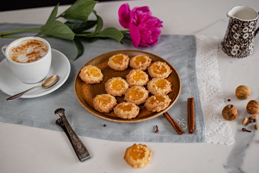 A selective focus shot of a cup of coffee with fresh homemade cookies