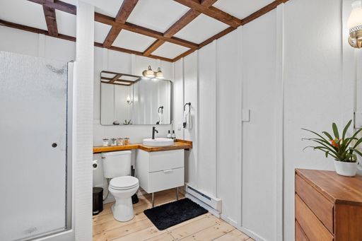A bathroom wooden white interior design featuring a countertop next to a large wall mirror