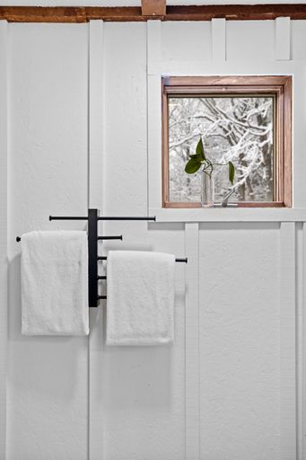 This bathroom has a white bath tub next to a window, giving you a nice view of the outside world