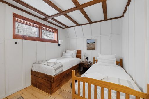 A comfortable bedroom features two beds each next to a window