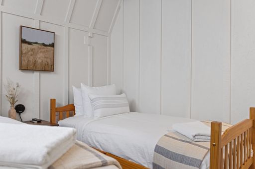 Two small beds in a white bedroom next to each other