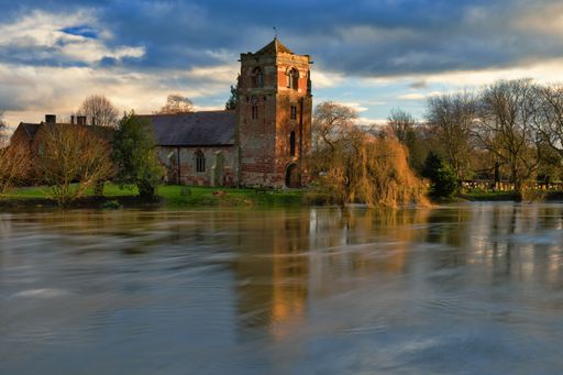 A tranquil view of the Church at Atcham, Shropshire, England, reflected in the River Severn