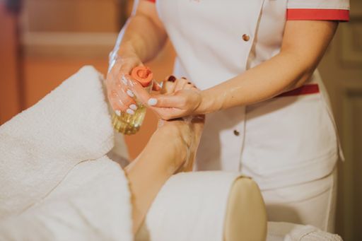 The woman getting a relaxing foot massage treatment in the spa salon