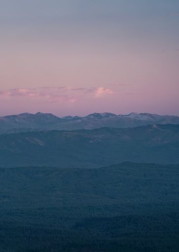 A vertical shot of purple toned vibrant sunset over mountains