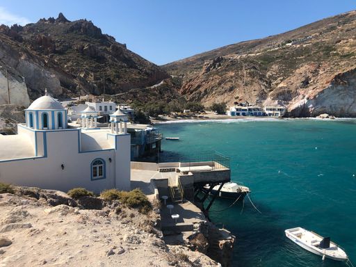 Aerial view of Milos, Greece, with a fishing village nestled amongst the rocky cliffs