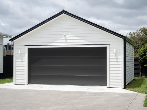 A white and black garage door with a grey roof and two windows