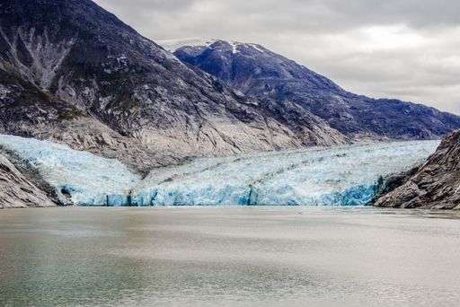 A beautiful view of a glacier on the seashore in the mountains under a cloudy sky