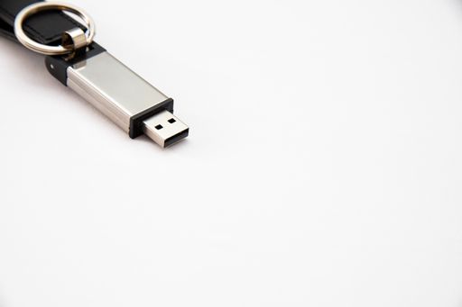 A closeup shot of a gray USB stick on a white surface