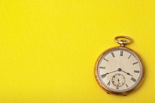 A clock on a yellow surface - time management concept
