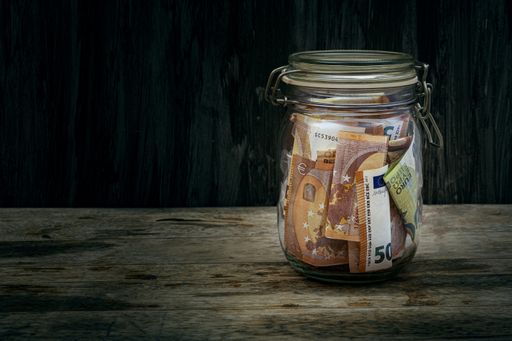 Euro Bills in Glass Jar on Vintage Dark Wooden Table. Save Money Financial Concept. Future investment.