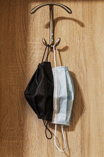 A vertical closeup shot of two face mask on a hanger on