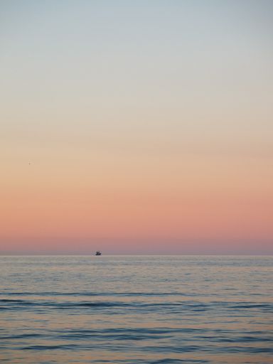 A vertical shot of the beautiful sunset sky over a peaceful sea
