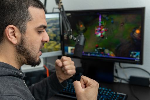 A Latino boy making a victory gesture for having won a computer game