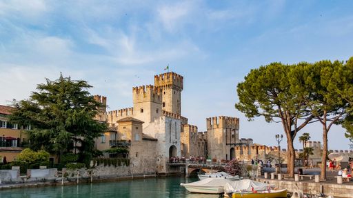 Tourists visiting a fairytale castle in Sirmione, Italy. 13th century fort, Rocca scaligera.