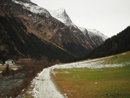 A landscape shot of a white pathway surrounded by high mountains
