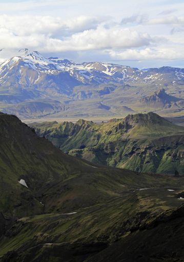 A vertical shot of beautiful mountains under a cloudy sky