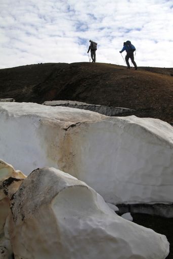 A vertical shot of a people hiking up the mountain