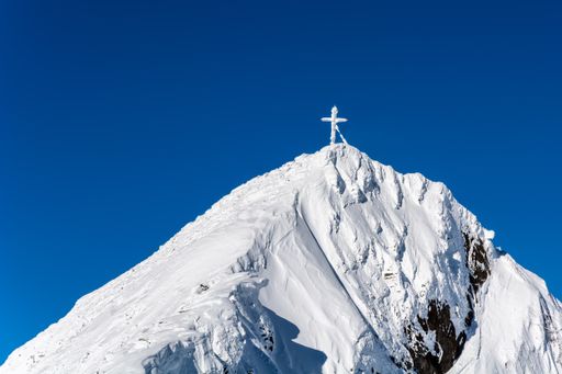 A beautiful view of a cross on on of the peaks of Hintertux Glacier on a cold day in winter