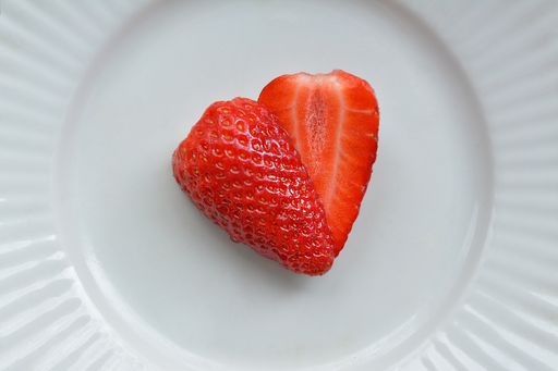 A closeup shot of fresh sliced strawberries on the white plate