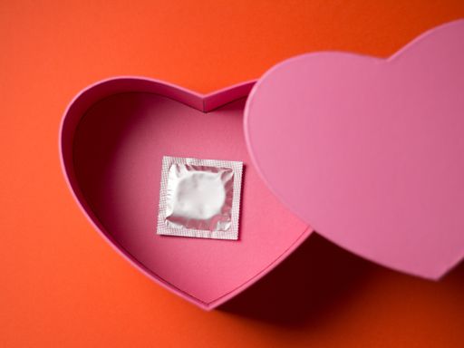 A top view of a condom in a heart-shaped gift box - valentine's day concept