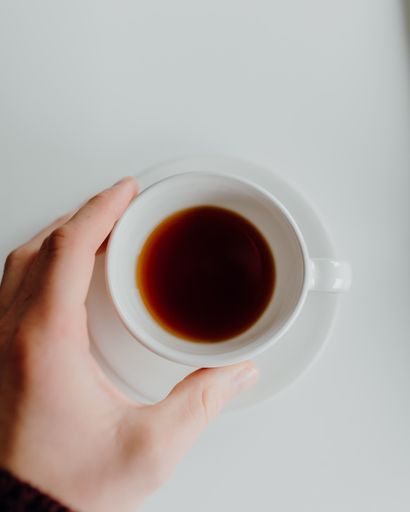 A top view of a hand holding cup of coffee