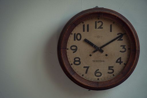 A closeup of a vintage round wooden clock on the wall
