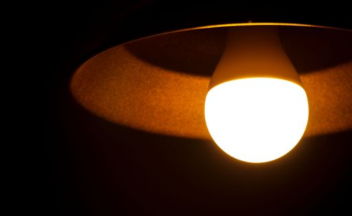 A closeup of a vintage light bulb illuminating a dark room