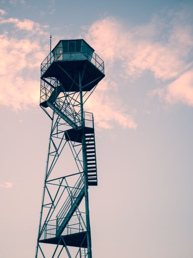 A vertical shot of an observation tower under the beautiful sunset sky