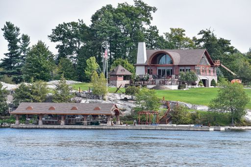 A lot of different buildings in a grassy area on the coast of a river during daytime