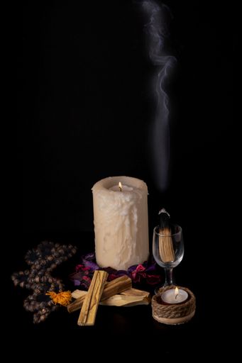 Smoking palo santo, holy stick with candles and japa-mala on black background