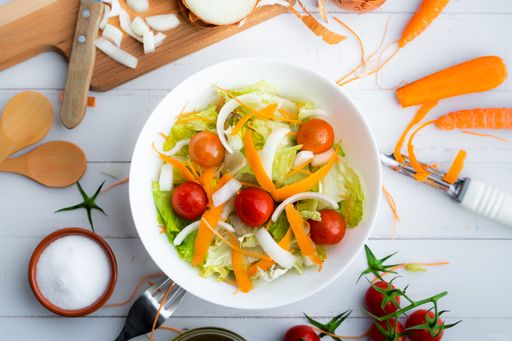 A top view of a healthy salad with vegetables and onions